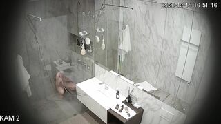 Busty girl washes and shaves in a large shower room