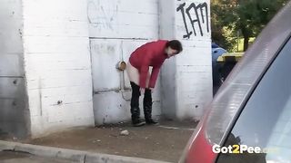 Naked babe with nice tits is pissing outside, while a horny voyeur is recording a video