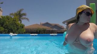 Busty Babe lounges on the pool and show us her giant boobs