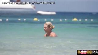 Bare-Chested damsel doesn't give a sex that everyone is gawping at her boobies, on the beach