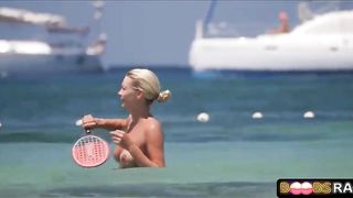 Bare-Chested damsel doesn't give a sex that everyone is gawping at her boobies, on the beach