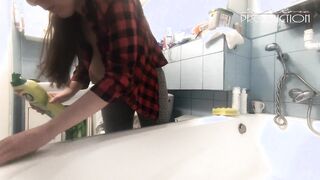 The housewife washes the bathtub. Her boobs are peeking out of her unbuttoned shirt