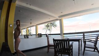 Nude lady ambles on the balcony disregarding the ocean